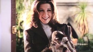 Jennifer Aniston smiles while holding a kitten in a doorway in 'Til There Was You.