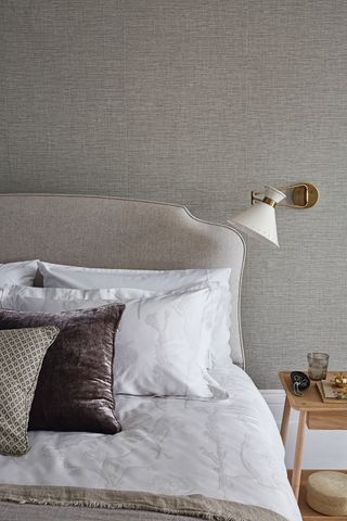 bedroom with textured grey wallpaper and a grey headboard