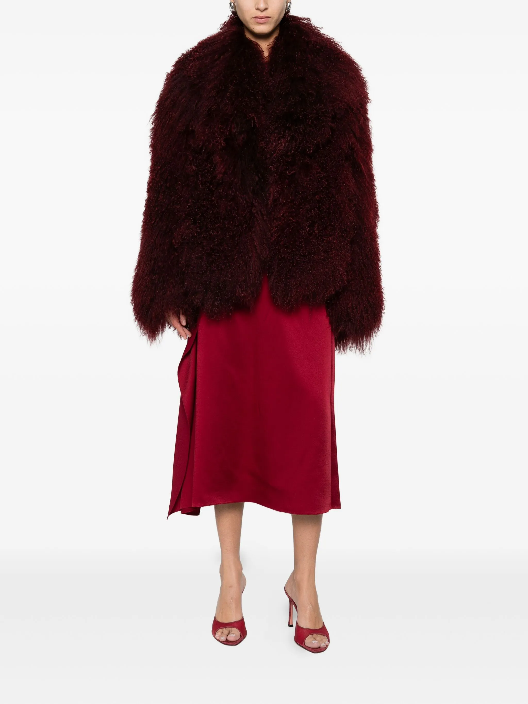 a model wearing a burgundy mongolian shearling faux-fur coat from nour hammour