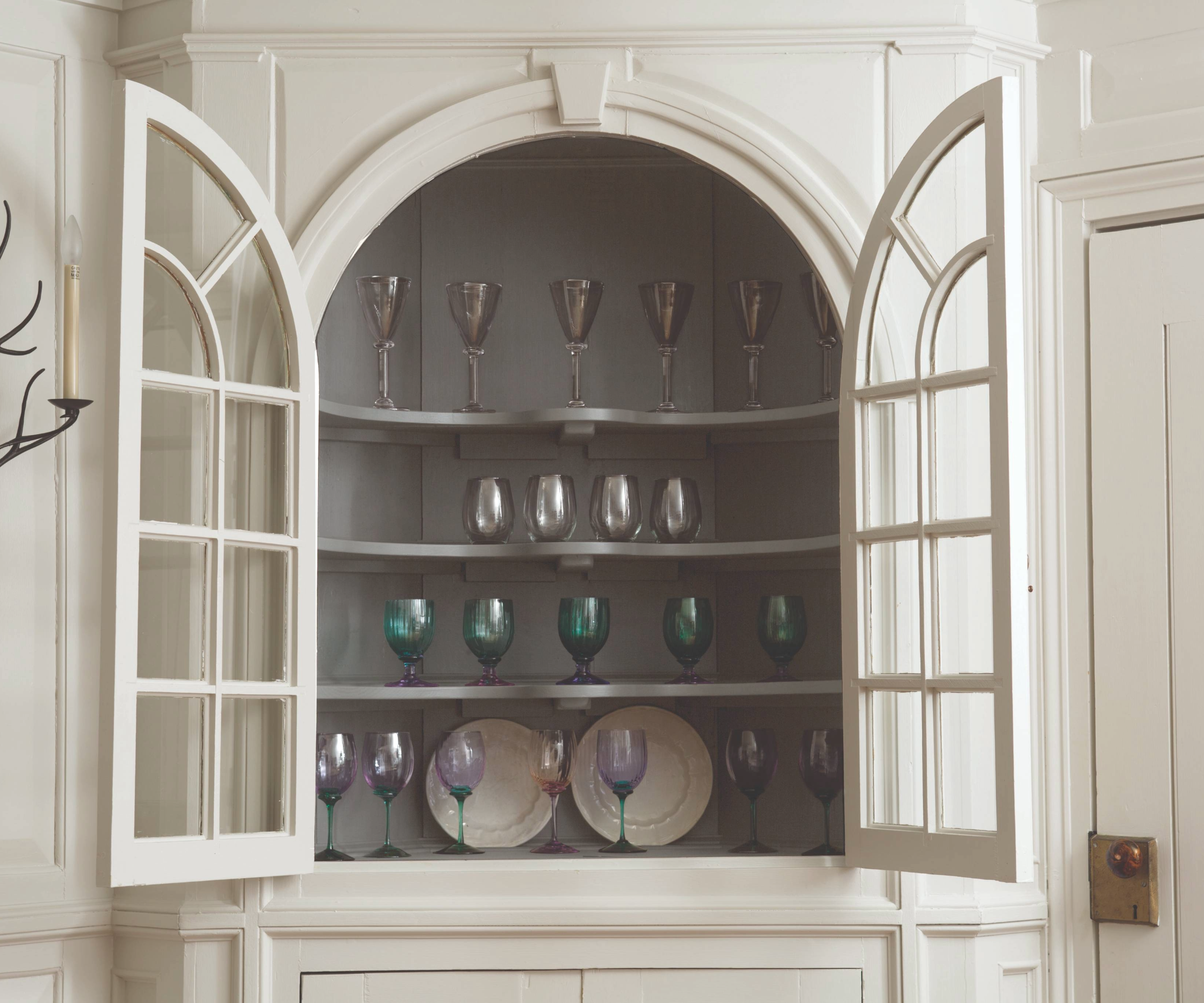 Alcove with build in glass cabinet with the doors open