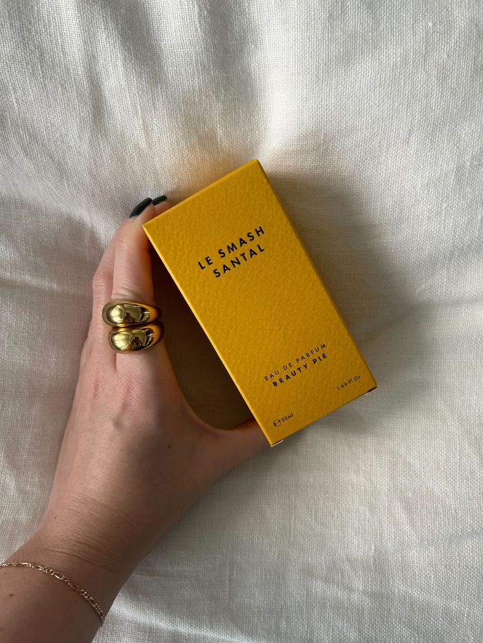 Junior beauty editor Grace Lindsay holding the Beauty Pie Le Smash Santal perfume