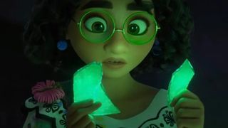 Encanto; a close up of a girl holding glowing green crystals