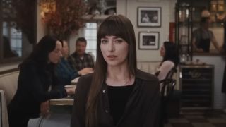 Dakota Johnson in Materialists talking to a client inquisitively.