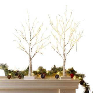 LED birch trees on a mantelpiece with garlands