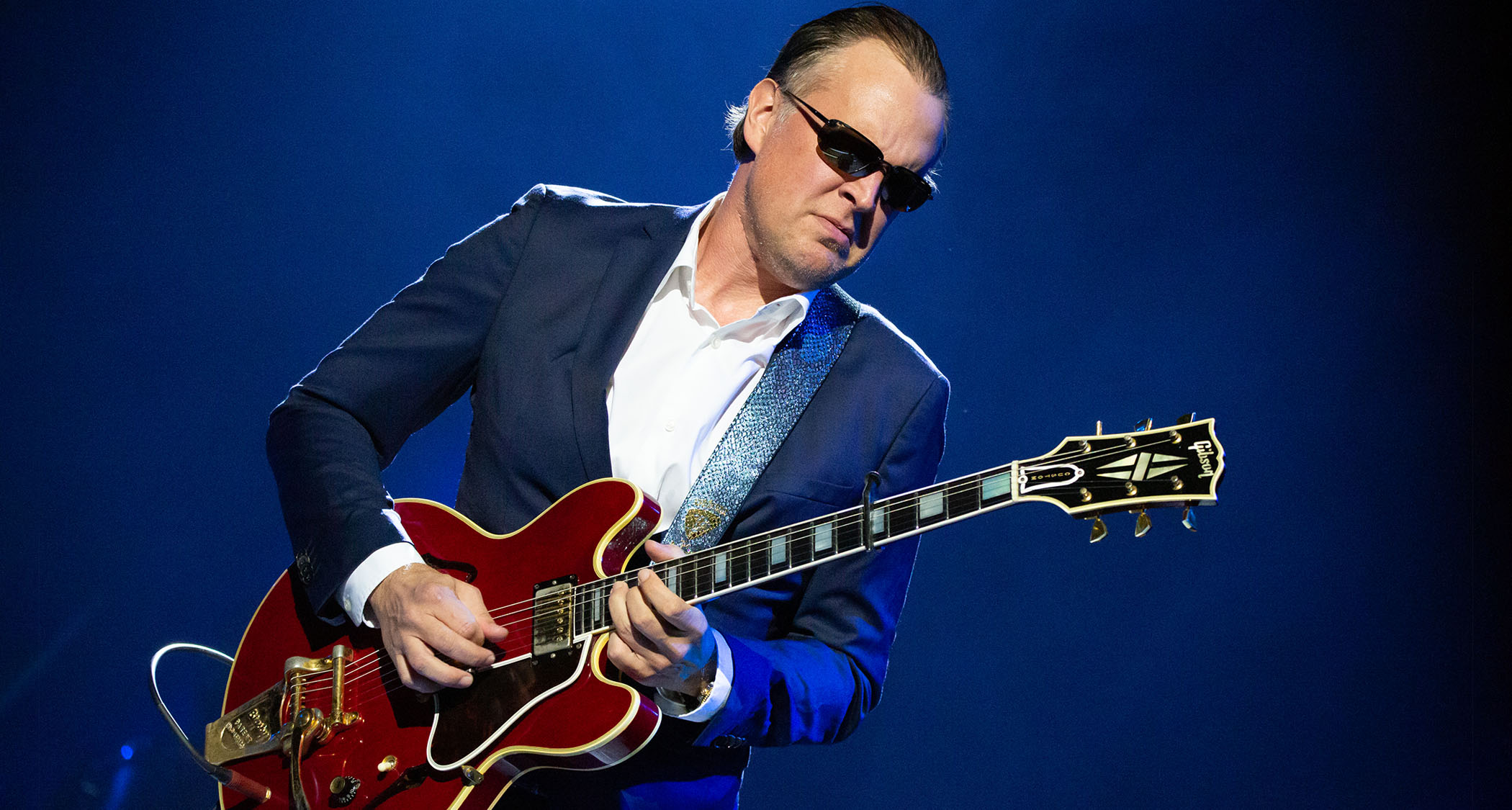 Joe Bonamassa wears shades and a dark blue suit, and plays an ES-355 Custom onstage in Leeds.