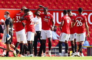 Manchester United’s Paul Pogba cools down by squirting water in his face during the first half drinks break