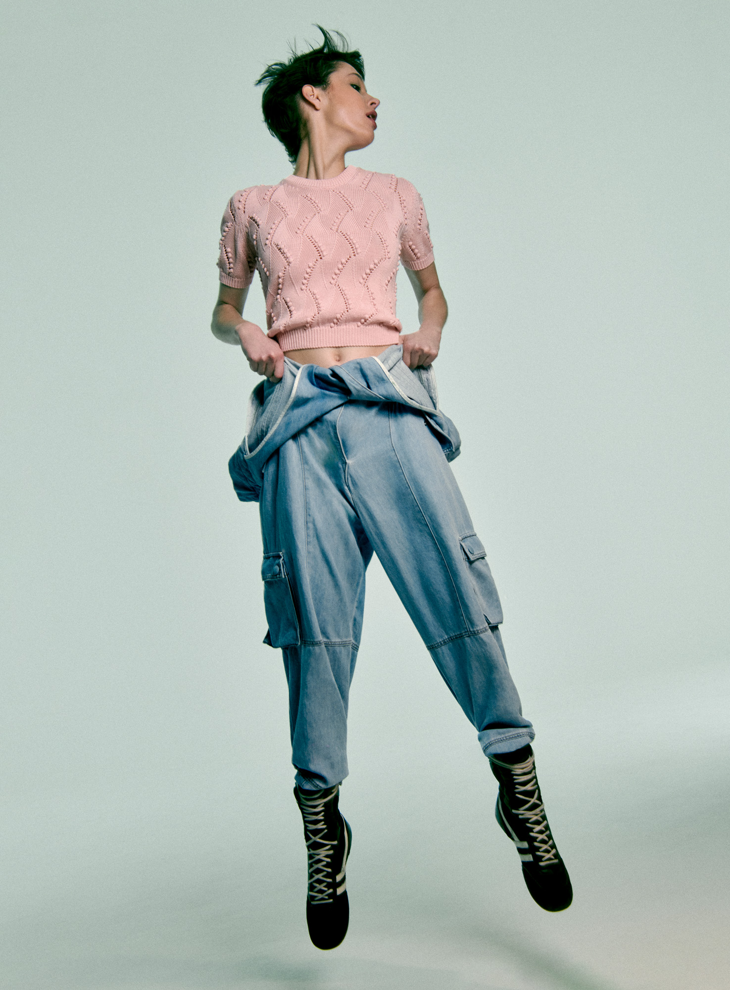 Woman jumping in Jacob Cohen by Matthew Adams Dolan denim jeans and sweater
