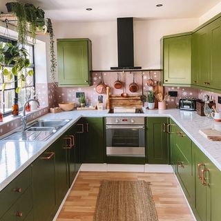 green and pink kitchen room with green cabinet and copper handles