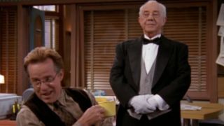 Phil Hartman chatting happily in front of Ian Abercrombie in NewsRadio.