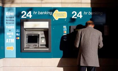 A man use an ATM on March 23 in Nicosia, Cyprus. The government has reached a last-minute bailout deal to rescue the island's failing banks.