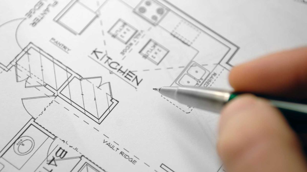 close up of house plans with pen