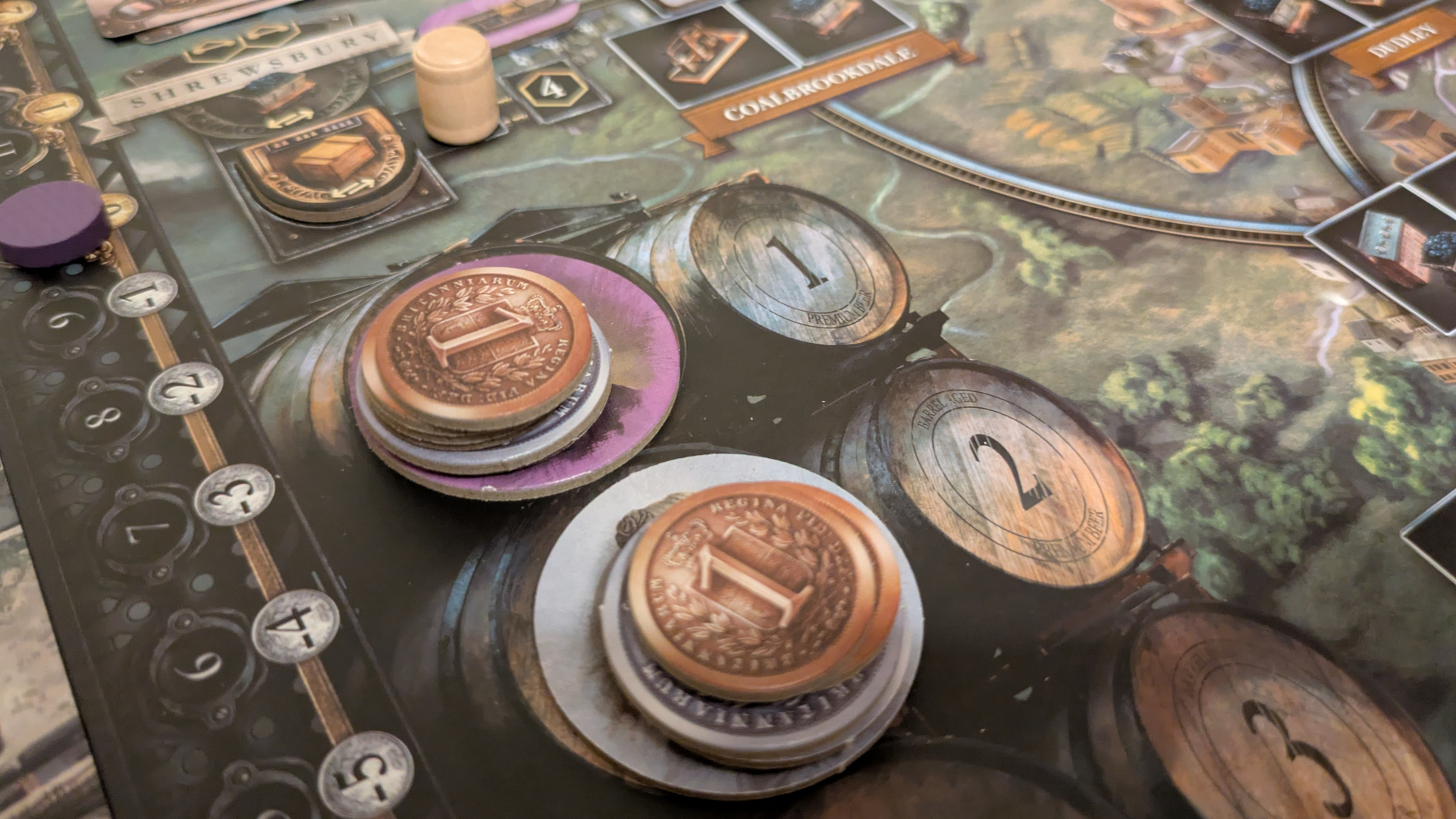 Coin tokens on top of the Brass: Birmingham board, with beer and crate tokens visible