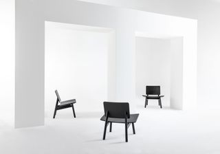 Black low lounge chair shown from the front, back and side on a white background