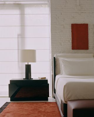 black bedside table in loft-style bedroom