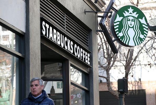 A man walks outside of a Starbucks.