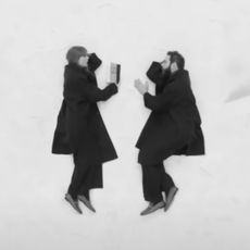 Taylor Swift and Post Malone laying on the ground wearing matching Gucci loafers