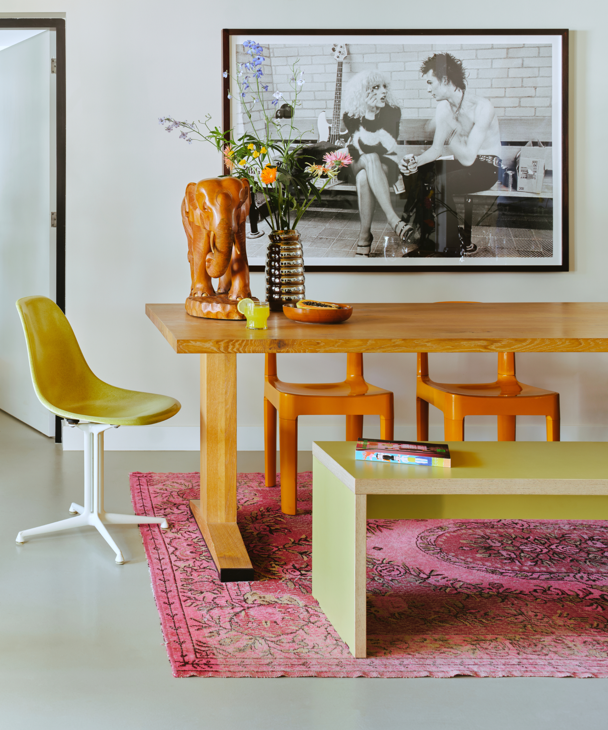 wooden dining table, chairs and bench with pink rug on tiled floor beneath table