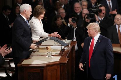 Nancy Pelosi reaches out to shake Trump's hand.