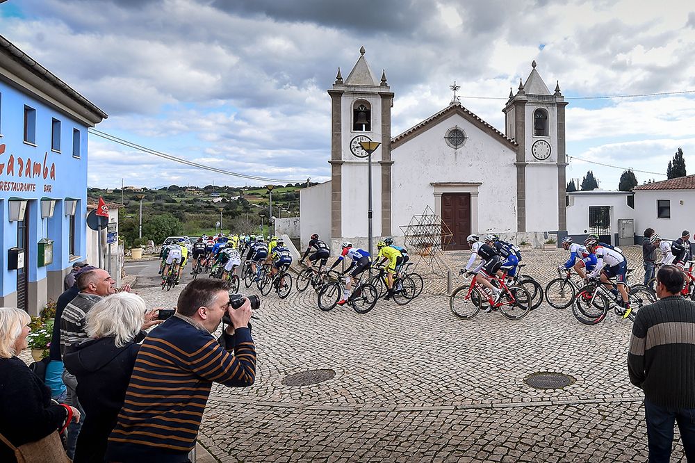 Fans watch the peloton pass by