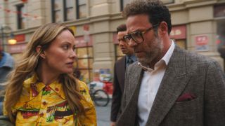 From left to right: Olivia Wilde and Seth Rogen walking while looking at each other.