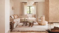 Cream living room with textured central fireplace, cream corner sofa, green armchair and wood and green marble coffee table