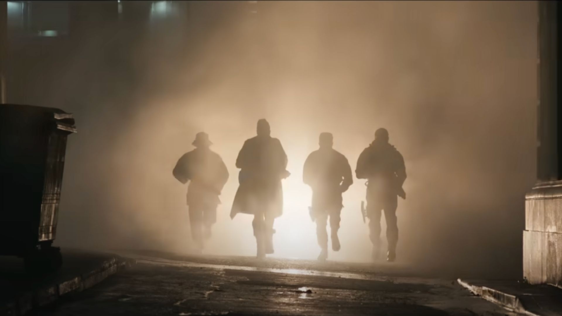 an image of four actors playing hunters running in shadow illuminated by a back light