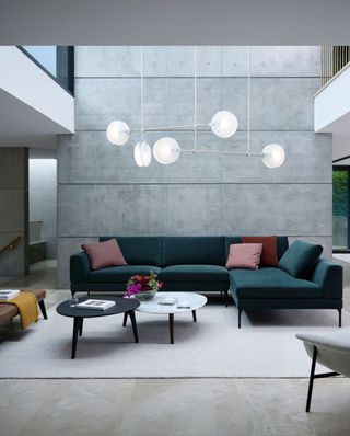 teal velvet sofa concrete wall living room by KING Living