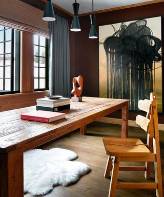 Wine room with wooden table and chair, contemporary black pendant lights and statement artwork