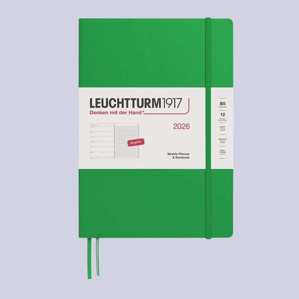A bright green weekly planner with a leaflet still positioned on its cover reading Leuchtturm1917 sits against a pale purple background.