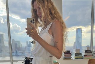 Olympia Gayot taking a mirror selfie while wearing a lace-trim top from J.Crew.