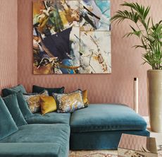 A living room with peach walls and a turquoise sofa