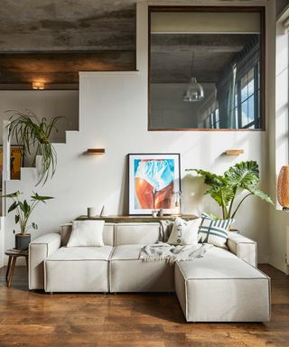 A living room corner idea by Swyft with modular sofa setup in Pumice situated in front of staircase with large window pane