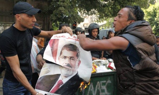 Egyptians burn a poster of ousted President Mohamed Morsi during clashes in central Cairo on Tuesday.