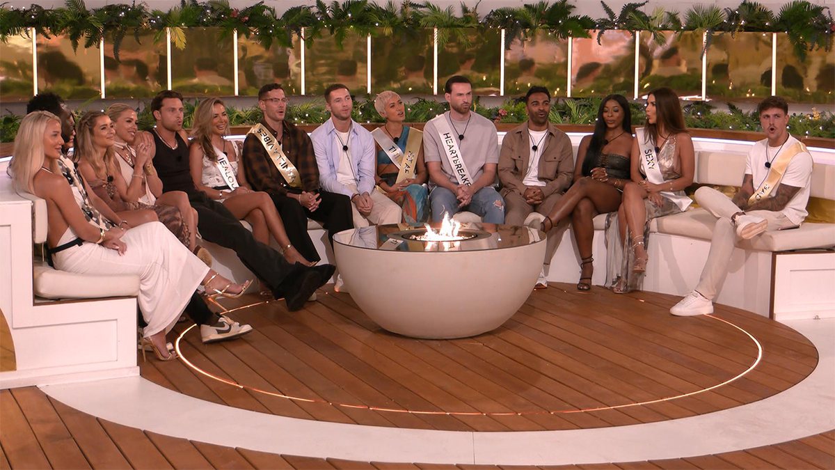 Islanders gathered around the fire pit playing a game in Love Island All Stars Season 2