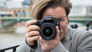The Canon EOS 80D being held to someone's face