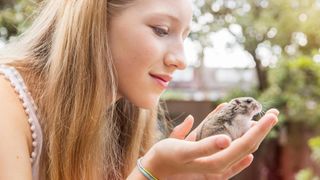 Teenage girl holding hamster