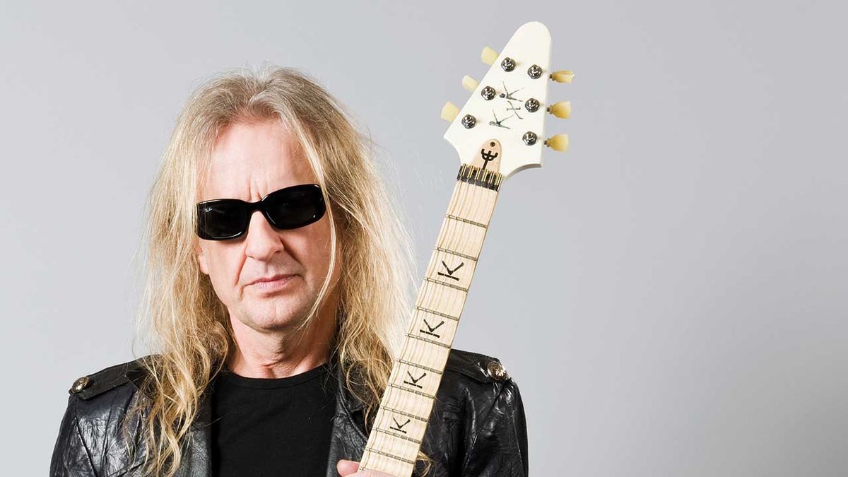 KK Downing holding a guitar