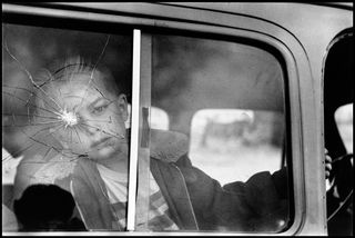 boy in car with bullet shot on window