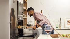 Man taking food out of broiler oven