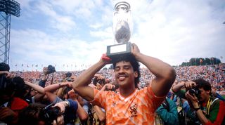 Frank Rijkaard of the Netherlands celebrates while holding the UEFA European Championship trophy in 1988