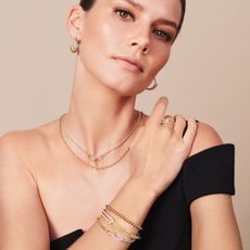 Model wearing black shirt and different jewelry pieces