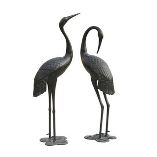 two metal crane statues on a white background