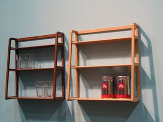 Two side by side three shelf wall fittings. Left: Four glasses on the shelves. Right. Two containers of Illy coffee on the bottom shelf.