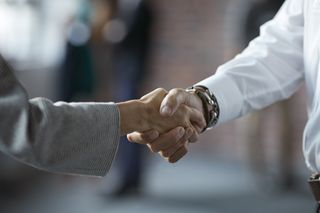 Two people shake hands