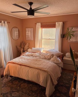 Monochrome and peachy small bedroom with soft bedding and drapes