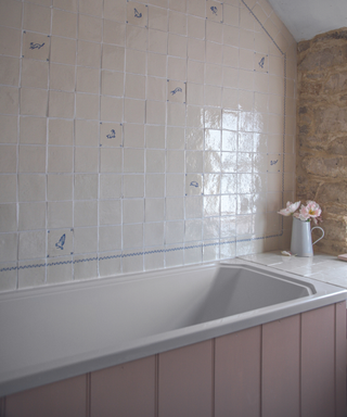 bathroom with patterned tiles and pink bath