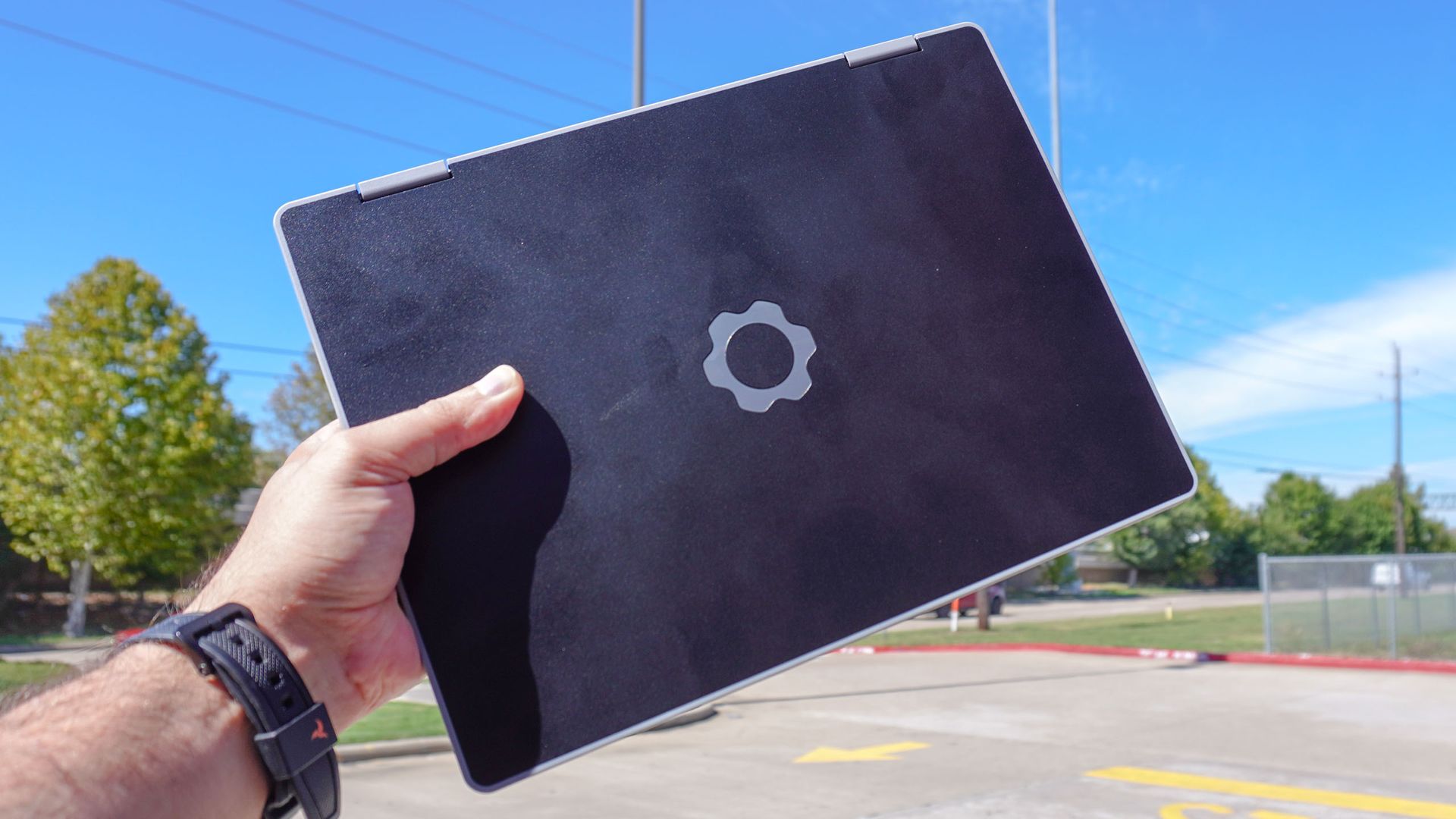 A person holding up the Framework Laptop 12 outside