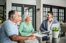 Financial advisor having a meeting with senior couple at home