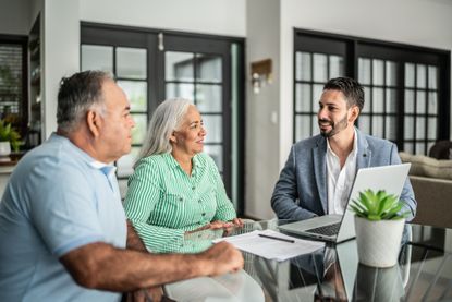 Financial advisor having a meeting with senior couple at home