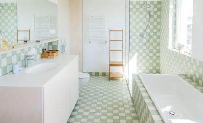 A bathroom with pastel tiles in green